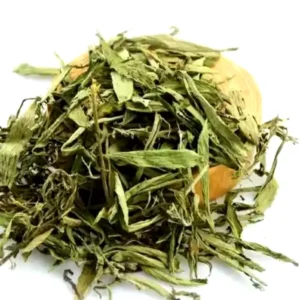 Hình ảnh cận cảnh một đống lá cỏ ngọt (Stevia) khô màu xanh lá cây nhạt được đặt trên bề mặt trắng, cho thấy rõ cấu trúc lá mỏng và hơi nhăn nheo của dược liệu. Lá cỏ ngọt khô tự nhiên, thường dùng để pha trà hoặc làm chất tạo ngọt. Sản phẩm chất lượng từ Thảo Dược Số 1.